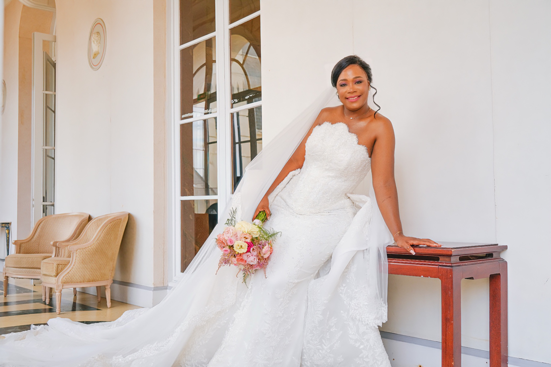 Mariée en robe à longue traîne dans un salon lumineux